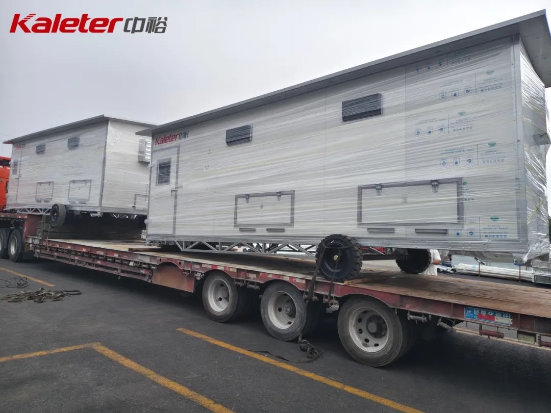 Two Kaleter mobile chicken houses loaded on a flatbed truck ready for shipment