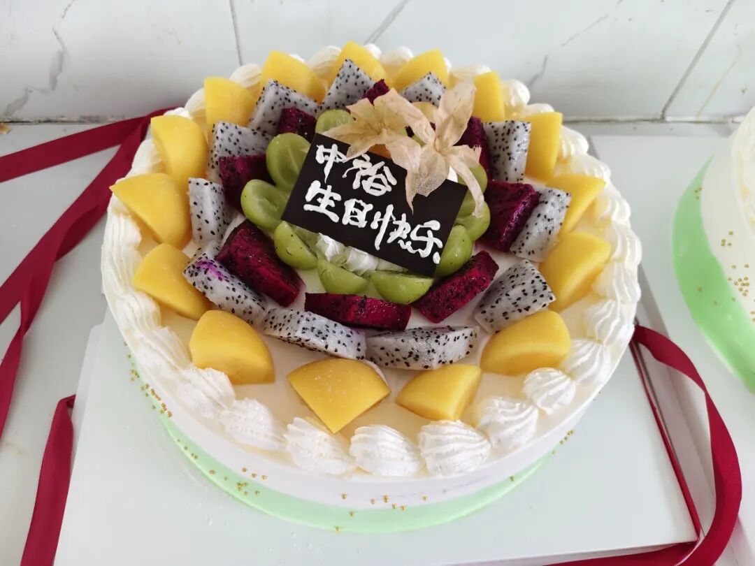 Fruit-topped birthday cake with a Happy Birthday sign for the September celebration