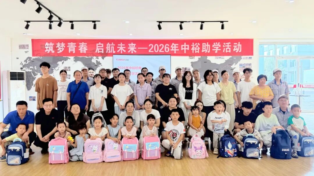 Kaleter employees, their children and the new school backpacks in a group photo under the event banner