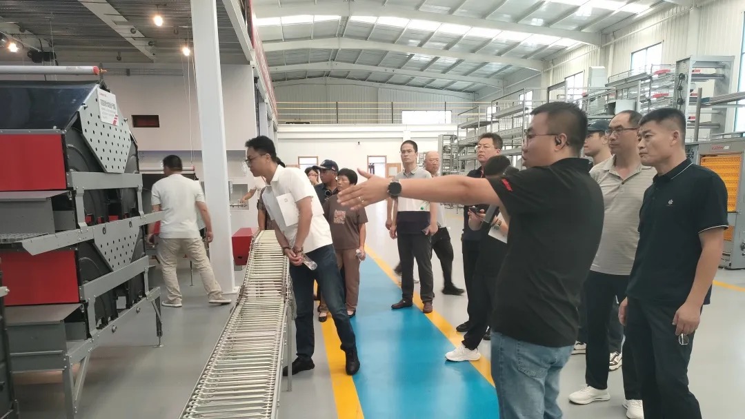 Forum attendees getting a hands-on look at Kaleter's cage-free equipment during the factory tour