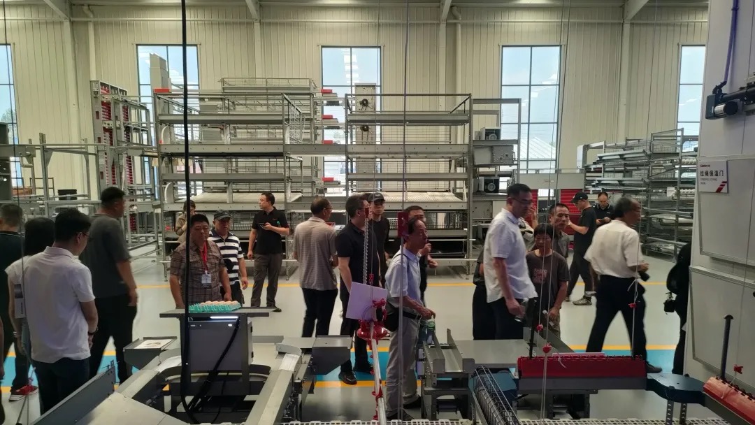 Forum attendees viewing Kaleter's cage-free housing systems on the factory floor
