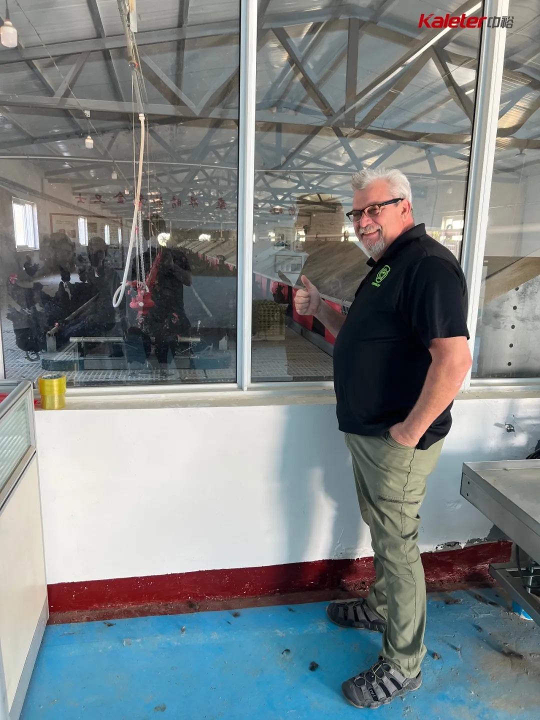 CloverLeaf auditor giving a thumbs up while overlooking the layer house from an adjoining room